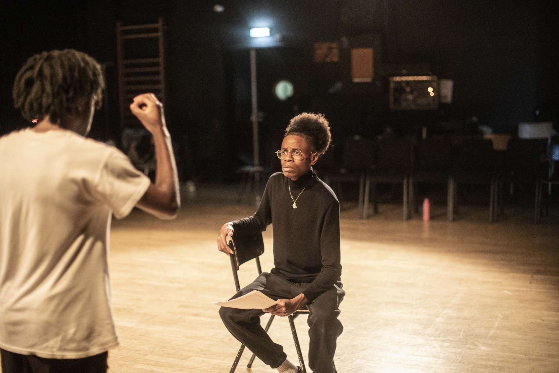 Groupe 50 élèves en atelier jeu avec Emmanuel Matte photo Jean-Louis Fernandez deux personnes en jeu l'une assise de face l'autre debout de dos la main droite levée