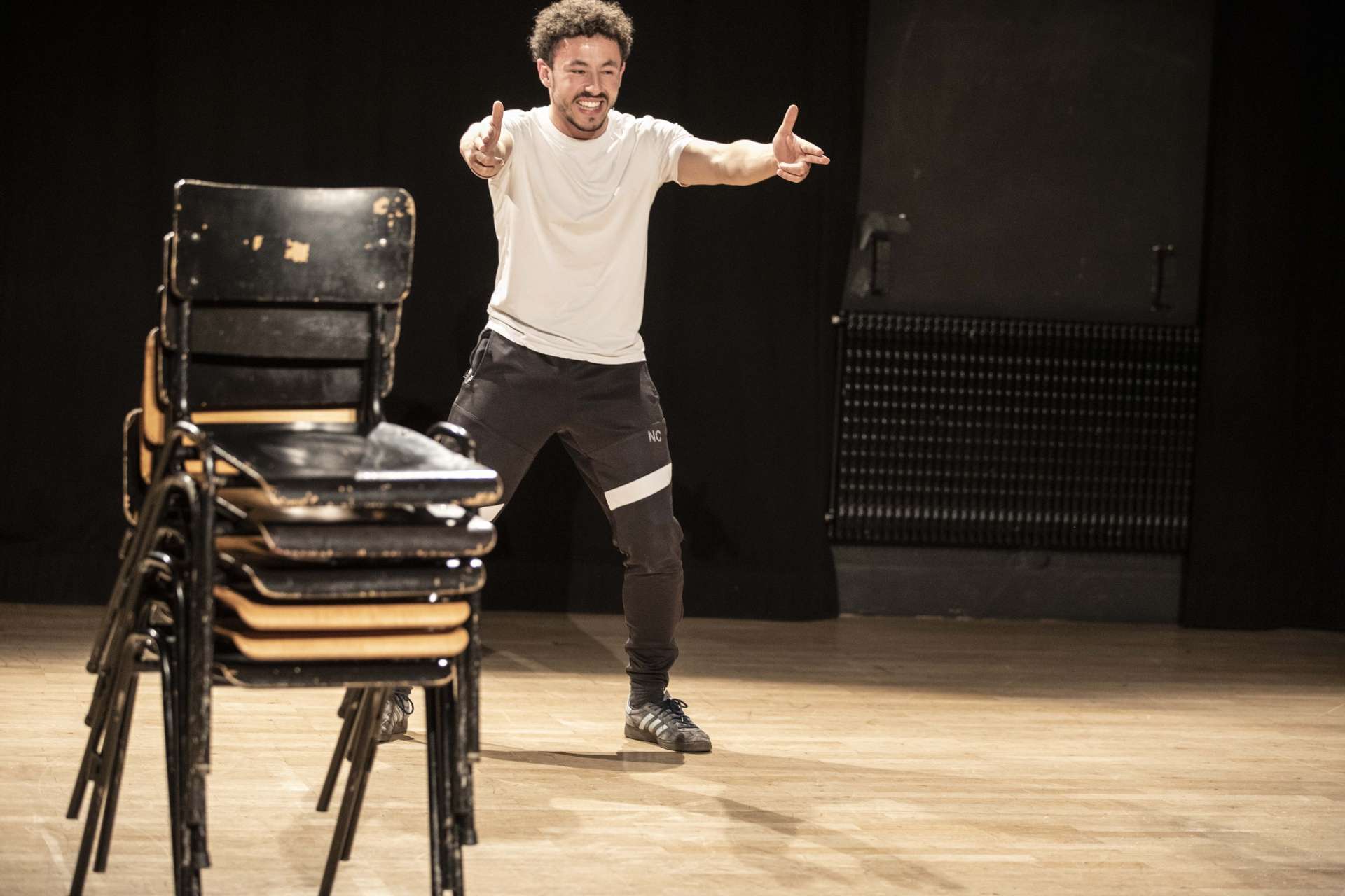 Groupe 50 élèves en atelier jeu avec Emmanuel Matte photo Jean-Louis Fernandez une personne debout au second plan, une pile de chaises noires au premier plan